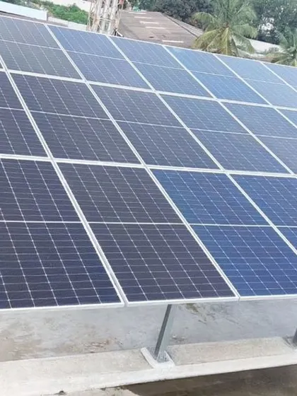 A member of Ranka Aquagreens Housing Society in Bangalore stands proudly next to their large-scale solar installation.
