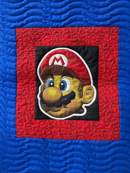 Another view of the Super Mario quilt, highlighting the different quilting patterns used in the background.