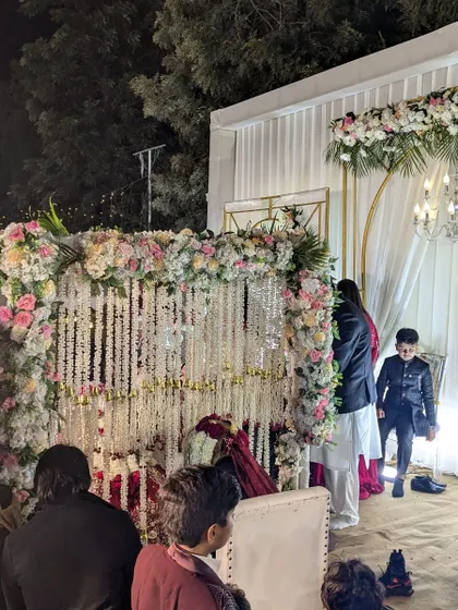 The Nikah ceremony in progress, with the couple seated behind the beautiful floral partition. This shows the decor in action during a real event.