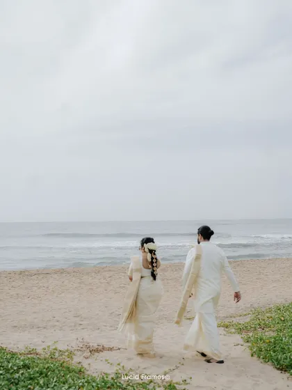 The couple walks away from the waves, hand in hand, stepping into their future together. A serene and cinematic shot.