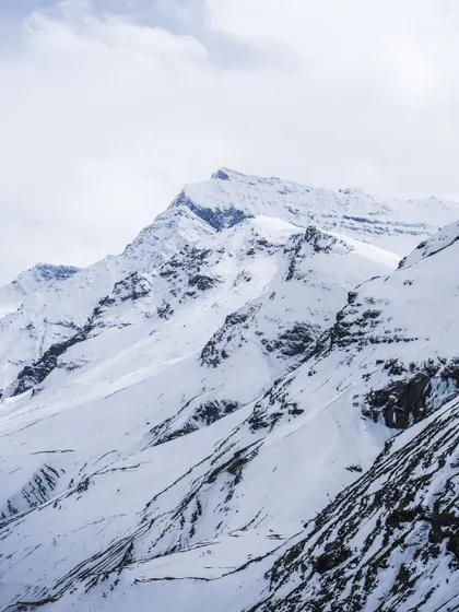 A crisp, clear view of the rugged, snowy mountains. The details in the rock and snow are highlighted by the bright, clear light.