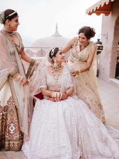 A precious moment between the bride, her mother, and her sister as they help her get ready.