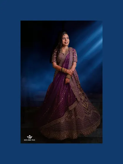 A portrait of the bride in a stunning purple lehenga, looking elegant and poised.