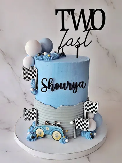 A tall, 8-inch double barrel cake for Shourya's "Two Fast" second birthday. This chocolate hazelnut cake has a vintage car theme.