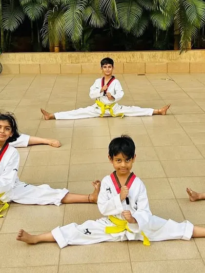 A group of our young students showing off their middle splits, a result of consistent stretching and hard work.