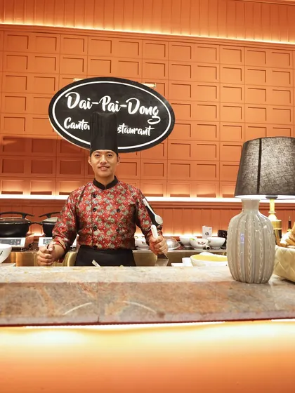 Our "Dai Pai Dong" Cantonese street food station, manned by a smiling chef. This concept brings the vibrant and bustling energy of a Hong Kong food stall to your event, offering a unique and memorable experience.