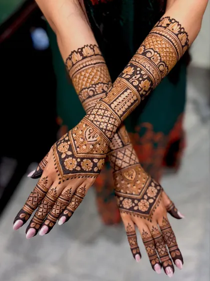 Another crossed-arm view, showing the intricate details and the rich color of the henna paste.