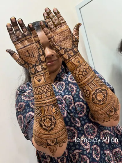 A full-coverage bridal mehendi that extends up the arm. This design is filled with a variety of traditional patterns, including checks, florals, and paisleys, for a truly grand look.