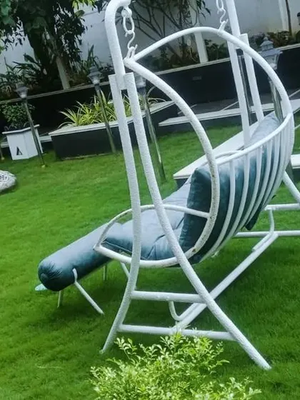 A close-up of a contemporary garden swing placed on a perfectly manicured lawn. This kind of feature adds a touch of comfort and style to any garden space.
