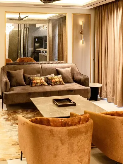 This living area demonstrates our skill in layering textures and colors. We combined sofas in different rich tones, a hide rug, and a large mirror with a gold frame to create a space that feels both glamorous and inviting.