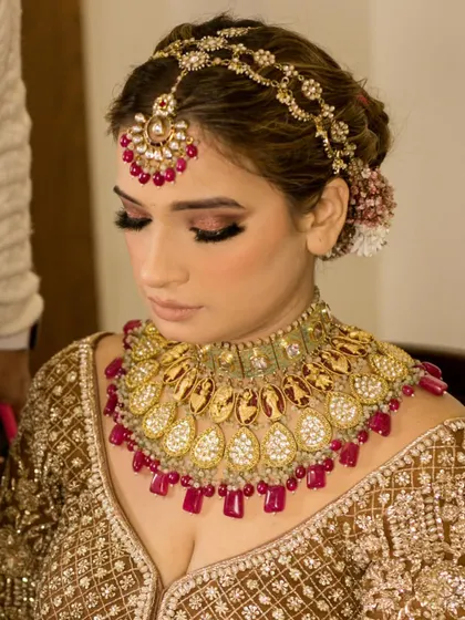 A close-up of the bride's stunning gold and ruby necklace and mathapatti.
