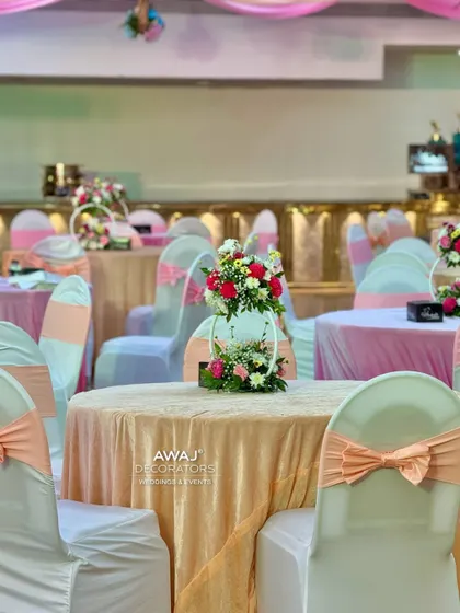 Elegant guest seating with peach-colored linens and chair bows, complemented by delicate floral centerpieces.