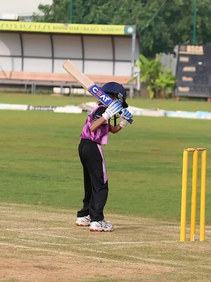 A U-10 batter plays a defensive shot, learning the importance of protecting the wicket.