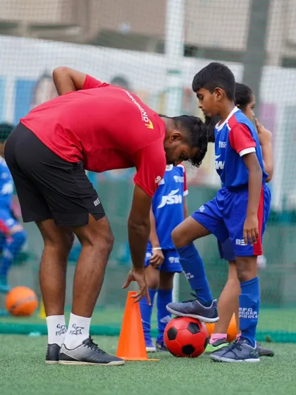 A coach demonstrates the correct ball placement for a drill. Attention to detail is a core part of our training, ensuring players build a strong technical foundation.