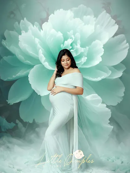 This mom-to-be looks so peaceful and radiant. The soft mint green gown and the giant floral background create a serene and beautiful composition.