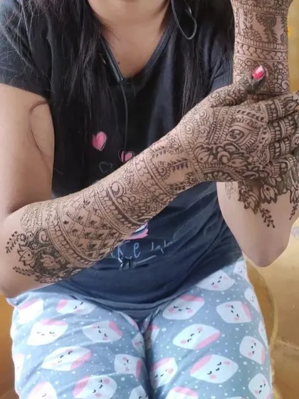 A side view of a bridal mehendi, showing the intricate patterns that cover the entire arm.