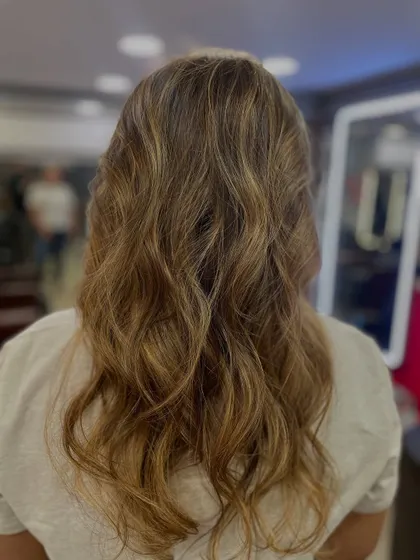 Soft, beachy waves with subtle highlights, expertly styled by one of our students. This shows their understanding of modern styling trends and techniques.