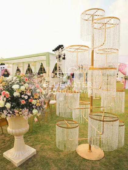 A unique, multi-tiered crystal installation adds a touch of modern glamour to the outdoor wedding decor.