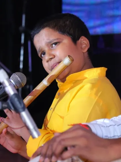 A teacher provides rhythmic support on the tabla as his student performs on the flute. This shows the collaborative and supportive nature of our live performances, where gurus guide their shishyas on stage.