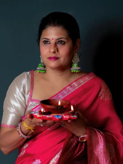 Celebrating Diwali with a diya. I styled this pink silk saree with a contrasting silver blouse and oversized green jhumkas for a bright, festive look.