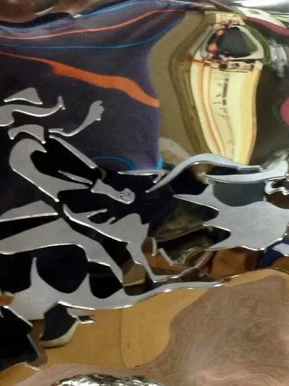 A close-up of the bull rider engraving, a narrative element on an abstract form.