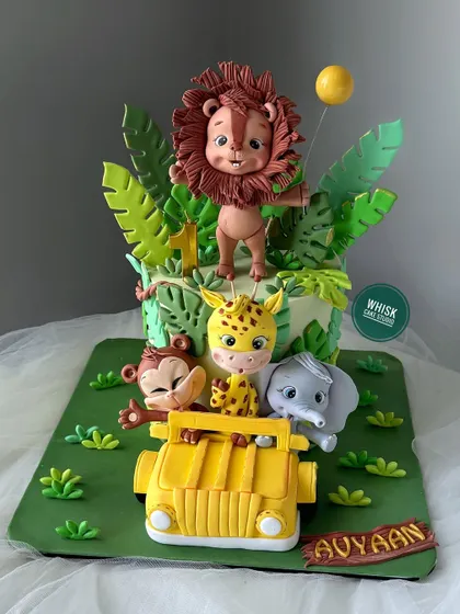 A single-tier jungle safari cake packed with adventure. This design features a group of cute, handcrafted animals riding in a jeep through the jungle.