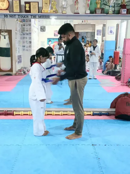 A young girl receives her blue belt.