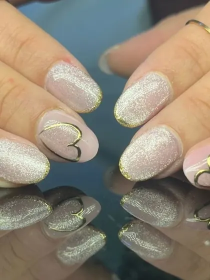 A romantic design with sparkling glitter nails and nude accent nails featuring a delicate gold heart outline.