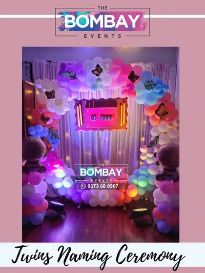 Double the joy! A beautiful butterfly-themed naming ceremony decoration for twins, featuring a colorful balloon arch and two baby foil balloons.