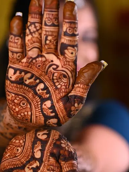 A close-up of the palm, showcasing the incredible detail of the peacock and elephant motifs.