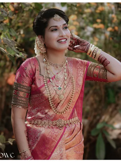 A close-up of the bride's happy expression and stunning gold jewellery.