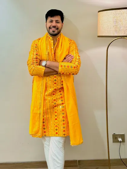 A full-length view of a festive yellow kurta paired with a white pajama, a classic and stylish choice for any daytime wedding event.
