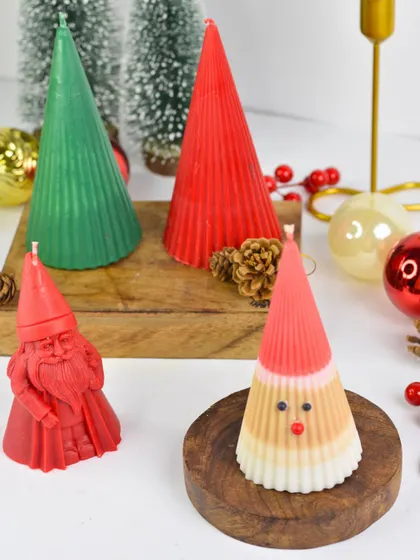 My collection of Christmas-themed pillar candles, including Santa Claus figures and cone-shaped trees in festive red and green. These are perfect for creating a holiday centerpiece.