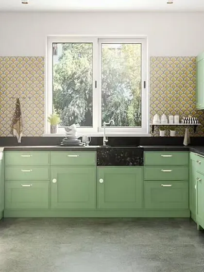 A charming, traditional U-shaped kitchen in a soft sage green. We included glass-front cabinets to display dishware and a large window over the sink to provide natural light and a pleasant view.