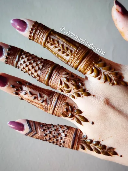 A close-up of minimalist finger designs, showcasing intricate bands and delicate leaf patterns that adorn the fingers without covering the entire hand.