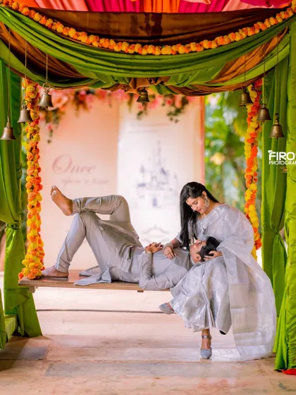 A relaxed and intimate portrait on a decorated swing. The couple is dressed in elegant, matching silver-grey outfits, creating a serene and romantic scene.