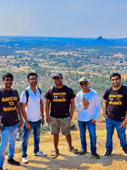 A team proudly wearing "Addicted to Wander" t-shirts, posing against the vast landscape at Nijagal Betta. This is the community I build.