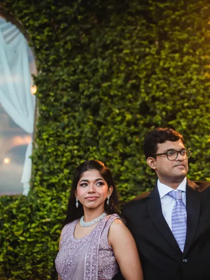A classic portrait of the couple at their reception. The lush green wall provides a beautiful, textured backdrop for this elegant shot.