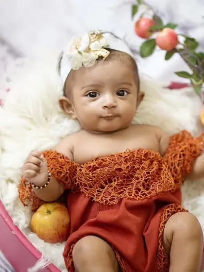 The apple of my eye. This three-month-old baby girl looks adorable in a heart-shaped bowl filled with fresh apples.