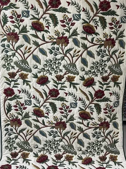 A stunning wall hanging with intricate floral and vine embroidery, showcasing a high level of hand-guided skill.