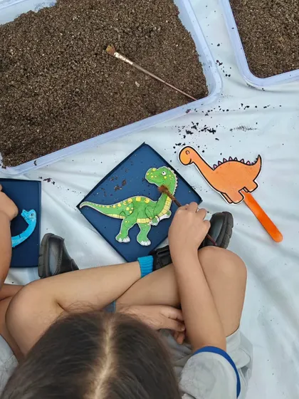 After excavating the pieces, the student begins to assemble and paint their dinosaur model, bringing the prehistoric creature to life.