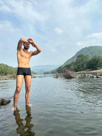A powerful stance against the backdrop of the river and hills.