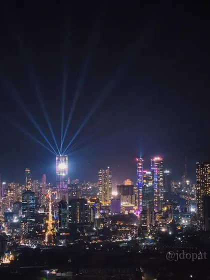The Mumbai skyline is lit up for Diwali, with the Palais Royale's spotlights shining into the colorful night sky.