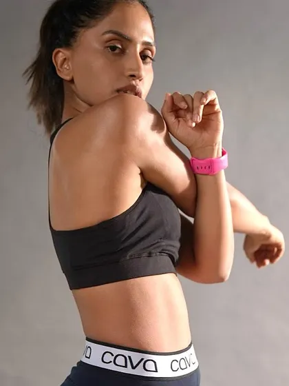 A professional shot from a photoshoot, showing a more serious, focused side while stretching.