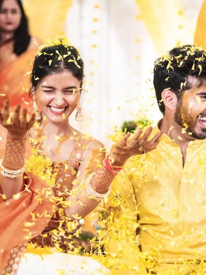 The couple playfully throwing petals at each other during their haldi.