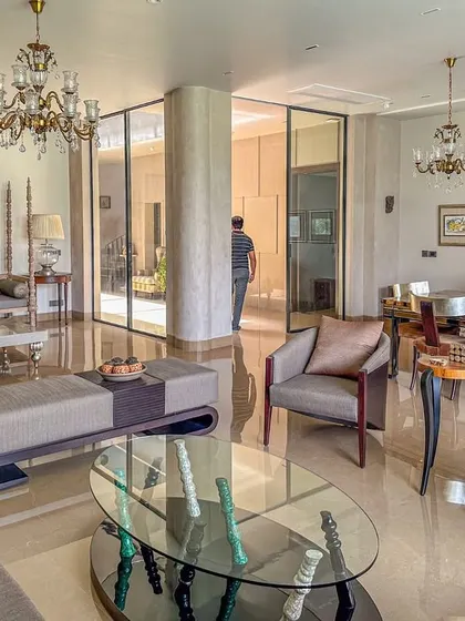 A view across the living room, showing the open layout and the connection between different seating areas. The design allows for both large social gatherings and more intimate family moments.