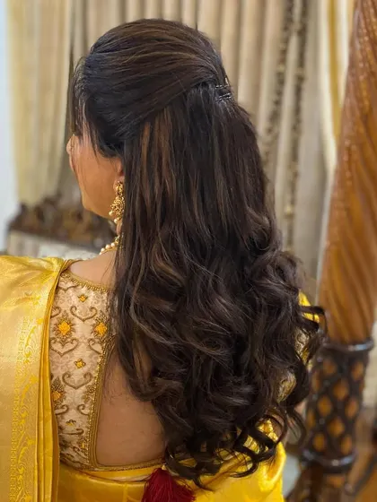 A soft, wavy hairstyle for a wedding guest, with a simple twist to keep the hair off the face.