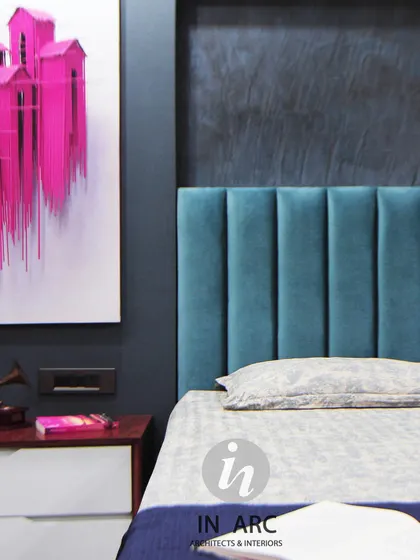 "There are two things that make a room timeless: a sense of history and a piece of the future." This bedroom detail shows a bold, textured blue wall with a channel-tufted headboard, complemented by vibrant modern art.