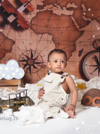 A simple and sweet portrait of a baby boy sitting in our aviator theme, looking curiously at the camera.