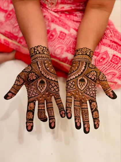 A closer look at the intricate henna for the bride's mom, showcasing the dark paste and the fine details in the floral and paisley work.